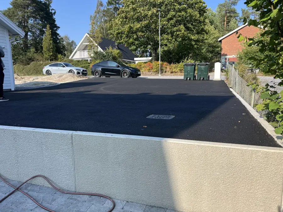 Samma uppfart efter asfaltering, jämn svart asfaltyta