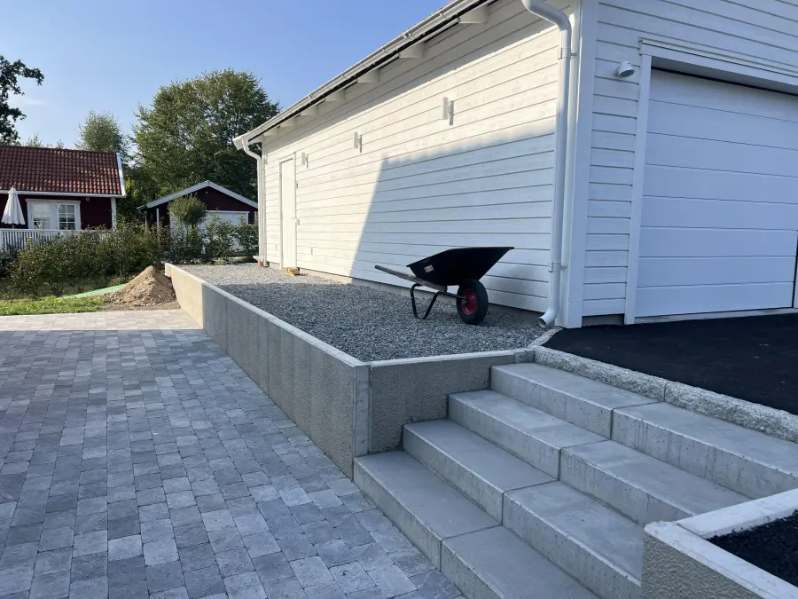 Uteplats med granittrappa och stödmur