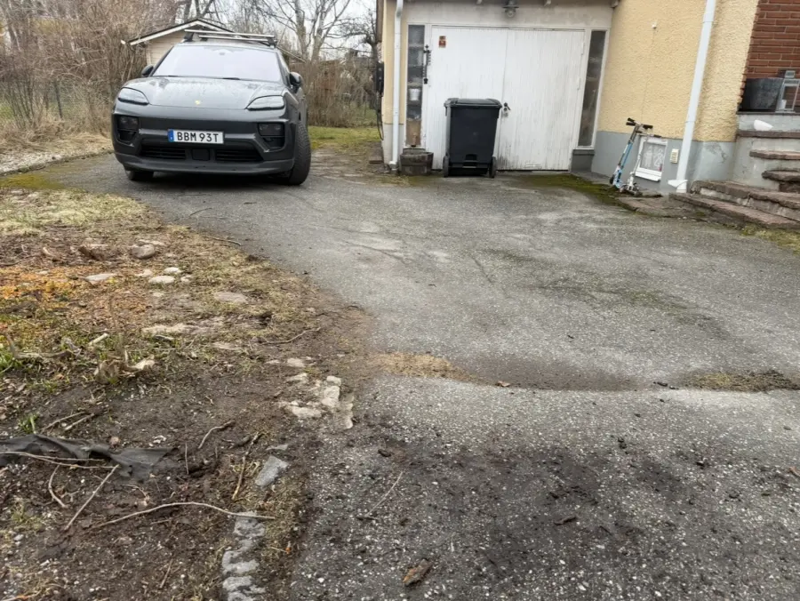 Sprucken och sliten asfaltsuppfart vid villa innan omläggning